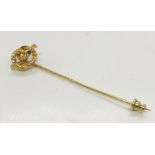 An unmarked high carat gold tie pin set with an emerald and seed pearls, total weight 1.6g
