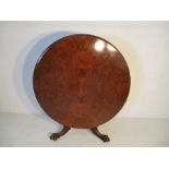 A walnut veneer circular tip up dining table on claw feet - diameter 130cm