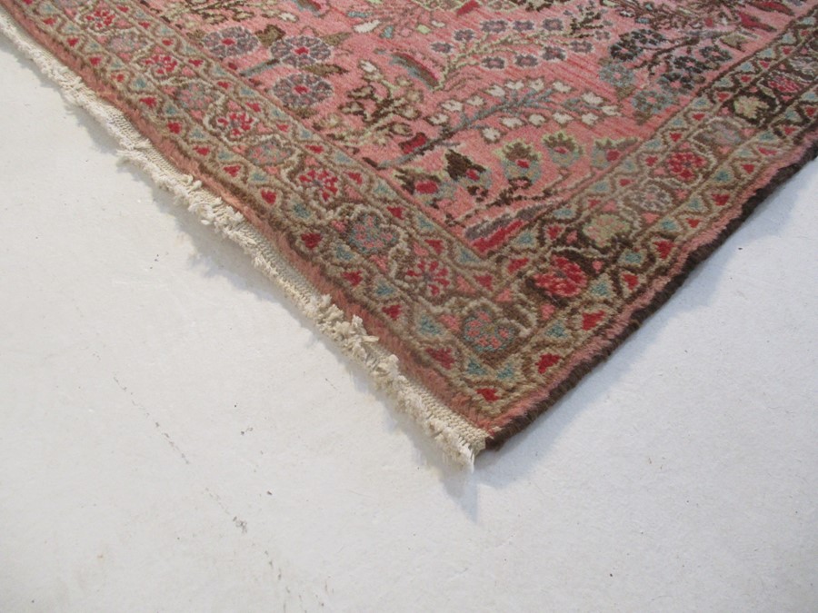 A Persian red ground rug - overall size 110cm x 70cm - Image 2 of 8