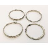 Four Chinese silver bangles, two decorated with signs of the Chinese Zodiac, one with stylised