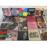 A collection of 7" vinyl singles in carry case including Queen, David Bowie, U2, Bruce