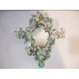 A 19th cherub encrusted continental porcelain wall mirror with floral decoration and three