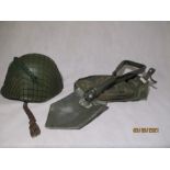 A military helmet along with a folding entrenching tool in canvas carry case