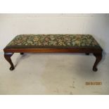 A long foot stool on cabriole legs with a tapestry insert.