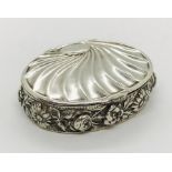 An oval hallmarked silver pill box with foliate decoration to edges