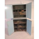 A two part metal shelving unit with pigeon holes and drawers, later wooden doors, height 191 cm x