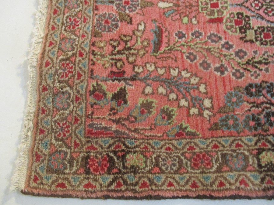 A Persian red ground rug - overall size 110cm x 70cm - Image 6 of 8