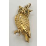 A 9 ct gold charm in the form of an owl with peridot eyes, weight 2.1g
