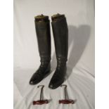 A pair of black leather horse riding boots along with wooden trees, boot pulls and carry bag
