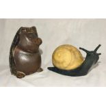 A large ceramic snail and a large hedgehog garden ornament