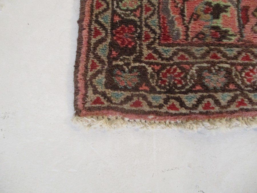 A Persian red ground rug - overall size 110cm x 70cm - Image 5 of 8