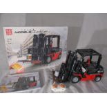A completed Mould King Forklift (13106) with original box and instructions