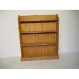 A freestanding pine bookcase - height 121cm, length 102cm