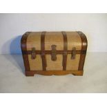 A wooden dome top trunk with leather effect straps