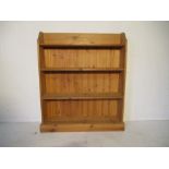 A freestanding pine bookcase - height 121cm, length 102cm