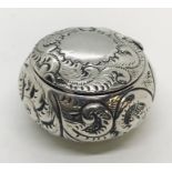 A hallmarked silver pill box with repousse decoration, 1886