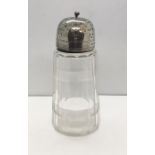 A cut glass sugar shaker with hallmarked silver lid