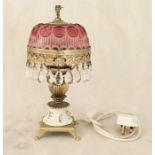 A decorative table lamp with cranberry coloured shade