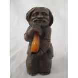 A small wooden carved figure ( possibly Russian) of a bearded man holding a piece of amber, marked I