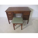 A vintage oak writing desk, along with an upholstered stool