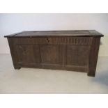 An antique converted oak coffer with carved decoration