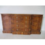 A break fronted yew sideboard
