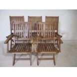 A set of five wooden garden chairs.