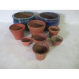 Two large glazed garden pots along with a selection of terracotta pots