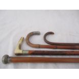 A silver mounted cane, silver topped walking stick and two others