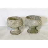 A pair of garden urns on plinths