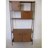 A mid-century metal framed display unit with three cupboards