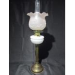 A brass oil lamp with white reservoir, glass frosted shade etched with floral pattern and funnel