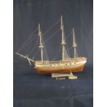 A hand built wooden model of a three masted warship in need of minor attention