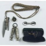 A 1916 A. De Courcy & Co. whistle, one other along with a pair of pince nez, compass etc.