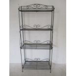 A wrought iron wirework shelving unit