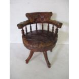 A turn of the century leather office chair with button back detailing