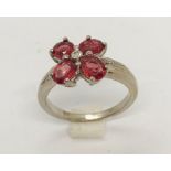 An 18ct white gold garnet "petal" ring with small central diamond