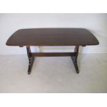 An Ercol rectangular dark wood refectory style dining table