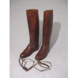 A pair of English brown leather riding boots, along with pair of spurs.