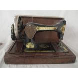 A portable Singer sewing machine in oak case