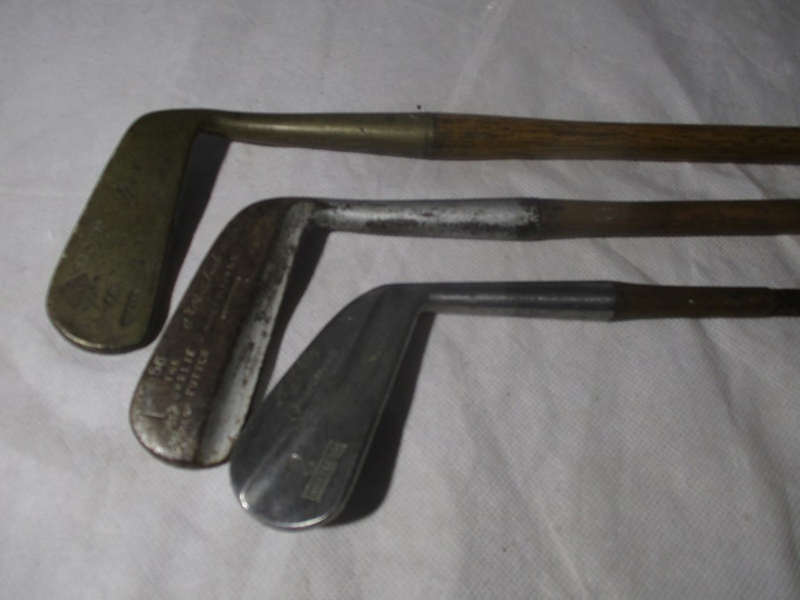 Three vintage golf clubs- two with Hickory shafts, including "The Leslie Putter", "Pyramid Putter"