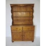 A pine dresser, two drawers, two doors, three shelves. Height 189cm Depth 44cm Width 110cm.
