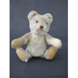 A vintage plush teddy bear with jointed arms and legs, height approx. 16cm