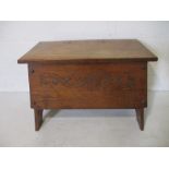 An Arts and Crafts elm blanket box with carved detail.