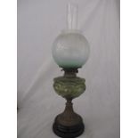 A Victorian oil lamp with decorative green glass well
