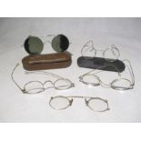 A pair of vintage tinted spectacles in tin by M.W.& Co Ltd along with various other spectacles etc.