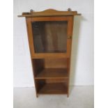 A narrow pine shelving unit with display cabinet above