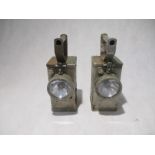 A pair of metal handheld miners lamps