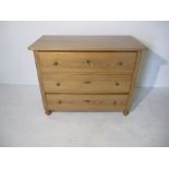 A pine chest of three drawers - height 82cm, width 103cm, depth 52cm
