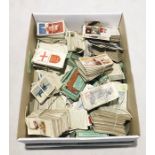 A box of assorted cigarette cards along with a collection of vintage playing cards